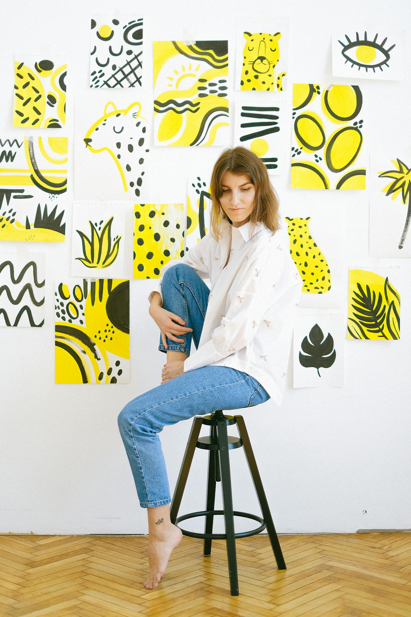 Woman in a creative indoor art studio with vibrant artwork on the walls.